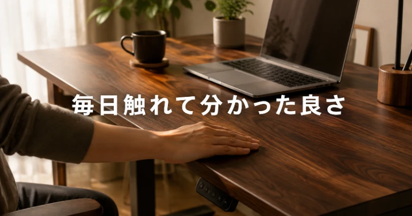 ダークブラウンの木目天板に手のひらを置き、手触りを確かめている様子。2週間使って実感した魅力の章の導入イメージ