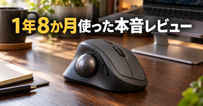 木のデスクに置いた黒いトラックボールと、奥のノートパソコン。1年8か月使った本音レビューのアイキャッチ